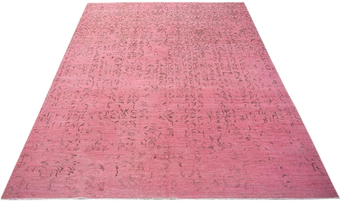 A rectangular, handwoven Afghan Chobi rug featuring a distressed, overdyed pink floral pattern.
