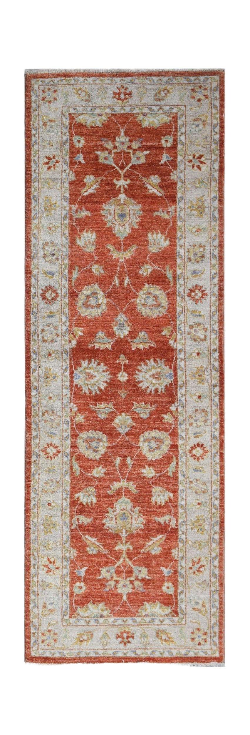 A handmade Afghan Chobi runner rug featuring a traditional floral pattern in rust and cream tones.