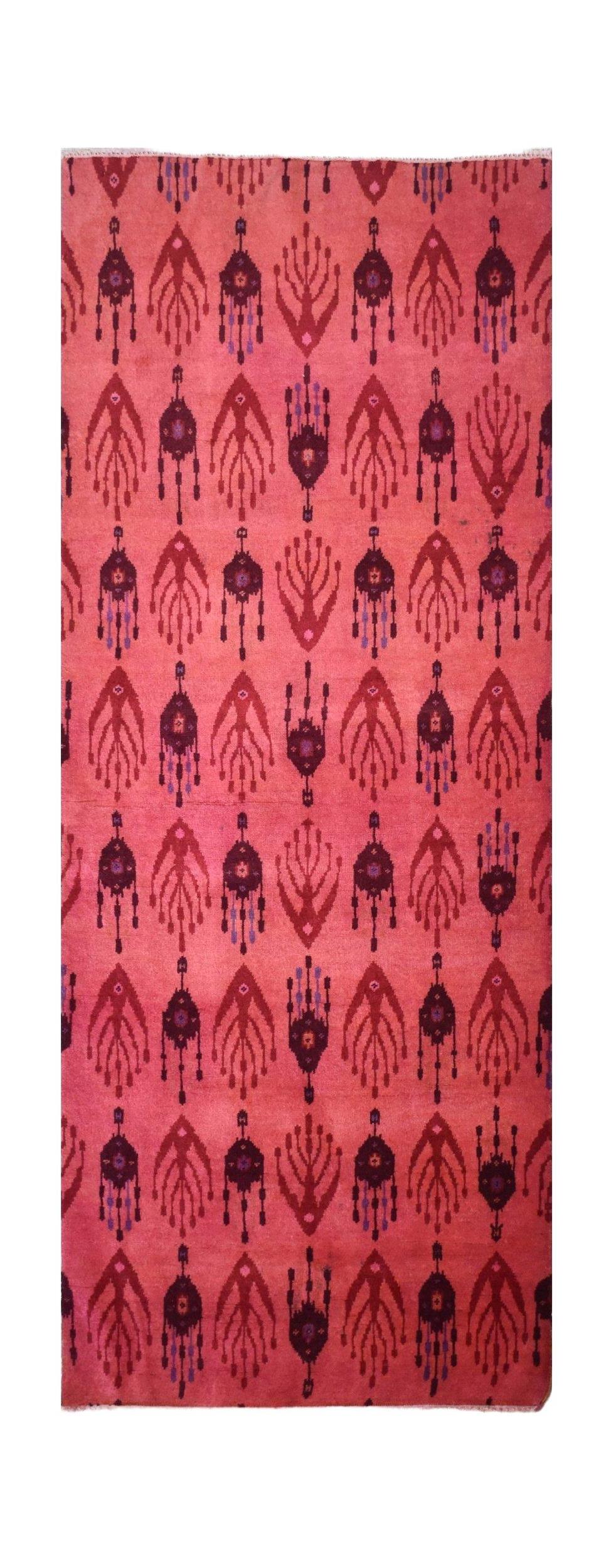 Handmade Afghan Chobi runner in a vibrant pink overdyed wool with a repeating ikat-style pattern.