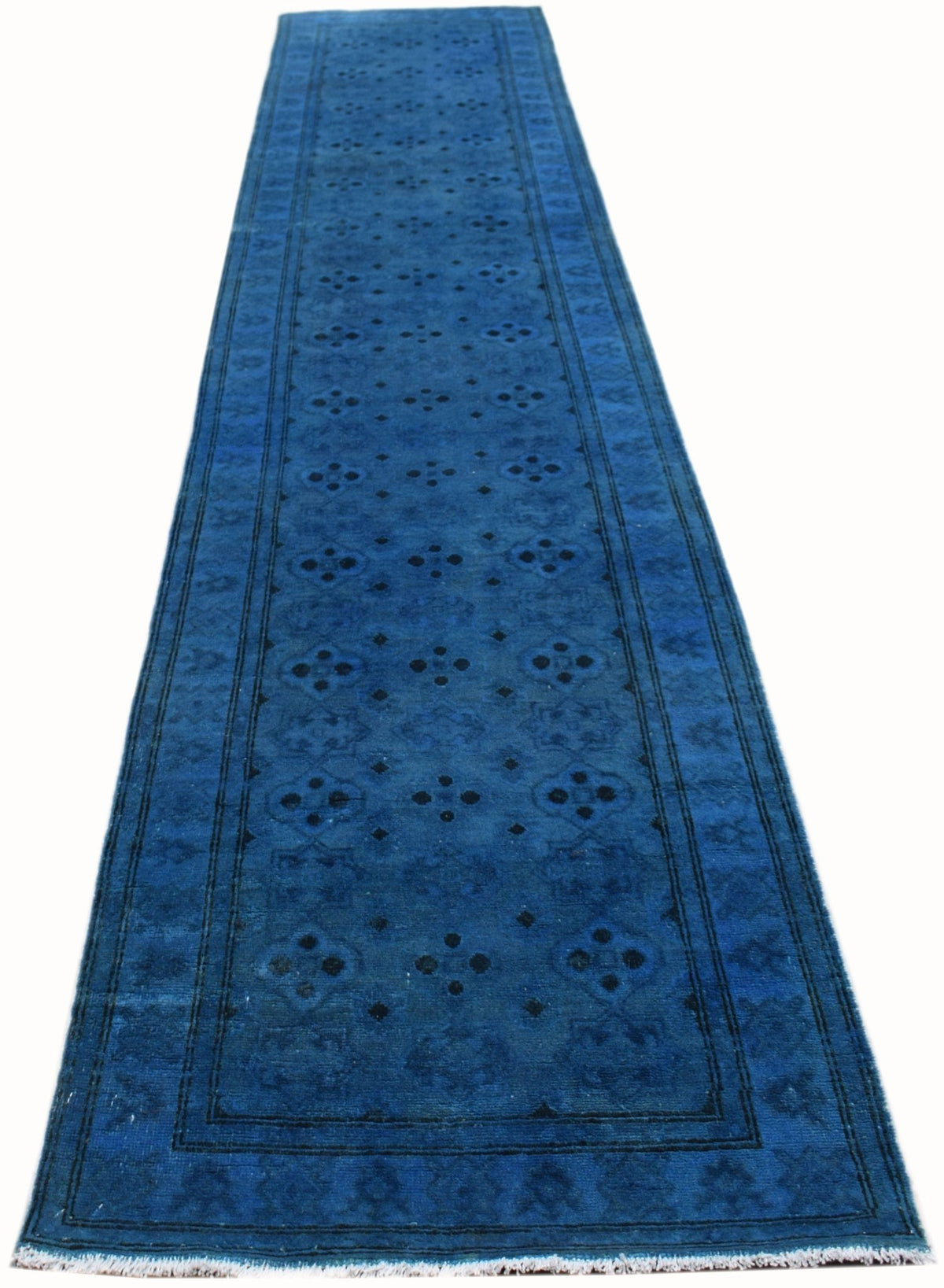 A long, handmade Afghan Chobi runner rug in a vibrant overdyed blue with a repeating floral pattern.