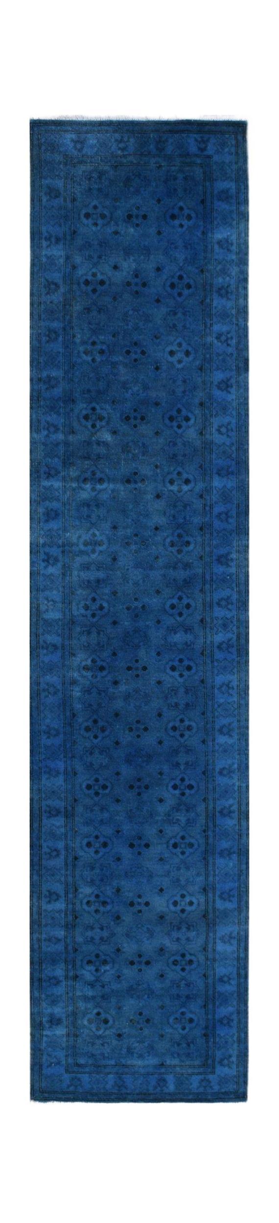 A handmade Afghan Chobi runner rug in a deep, overdyed blue with a subtle geometric pattern.