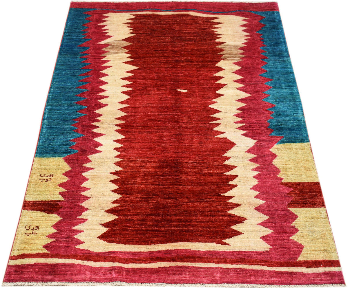 Handmade Afghan Gabbeh rug featuring a bold red center with jagged cream and blue borders.