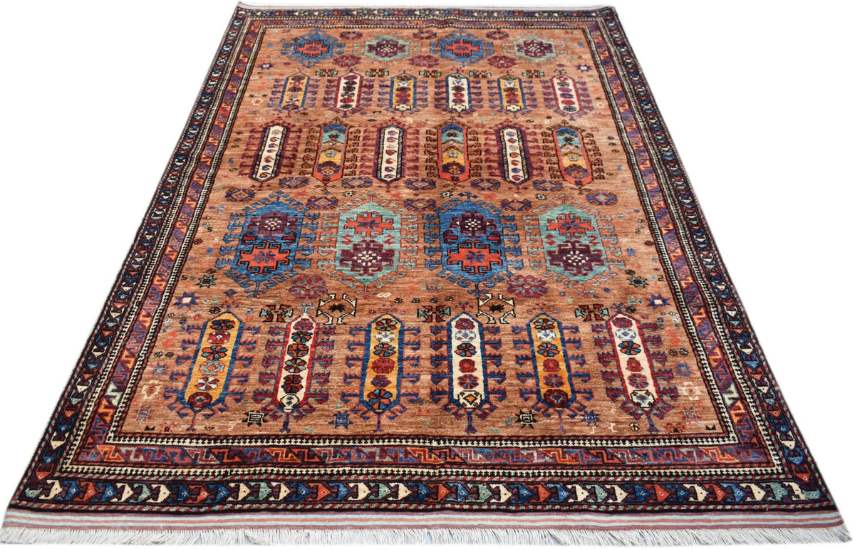Hand-knotted Afghan Herati rug in warm terracotta with blue, red, and cream geometric motifs and a detailed fringe.