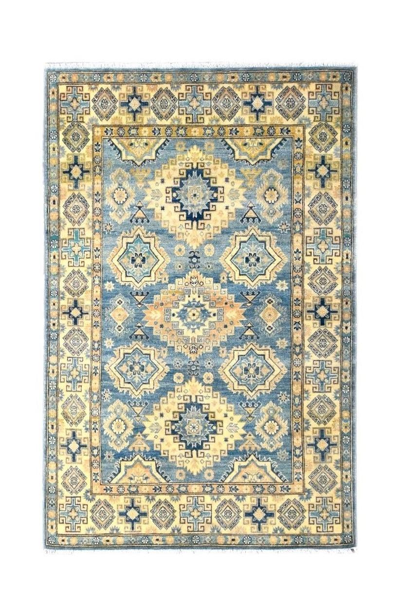 Handmade Afghan Kazakh rug featuring a geometric pattern in shades of blue and beige.