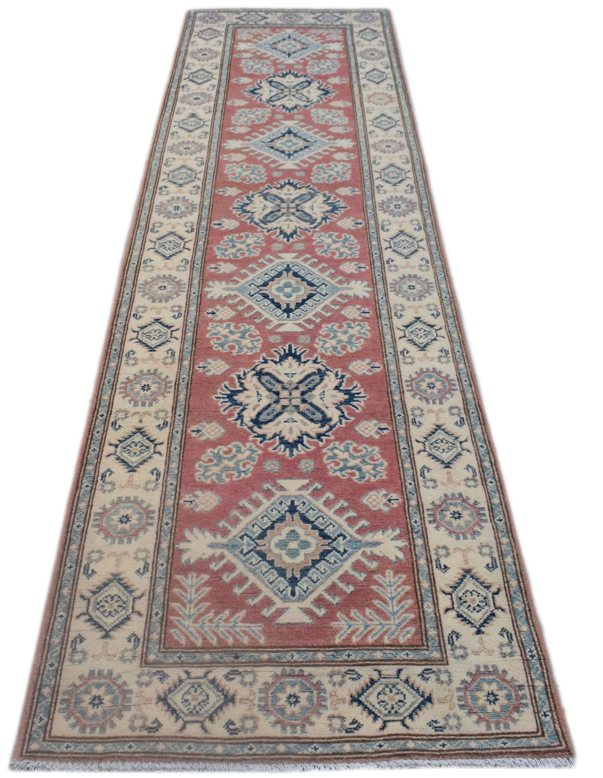 A handmade Afghan Kazakh runner rug featuring traditional geometric motifs in red, blue, and cream.