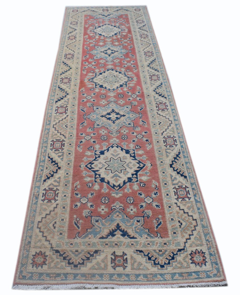 A handmade Afghan Kazakh runner rug featuring traditional geometric motifs in red, blue, and cream.