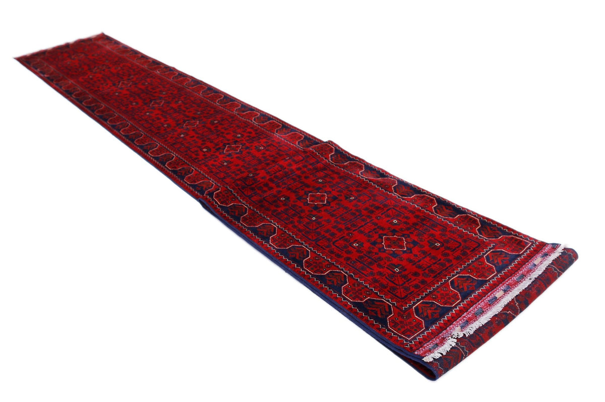Hand-woven Afghan Khal Mohammadi runner in deep red wool with geometric guls and a fringed edge.