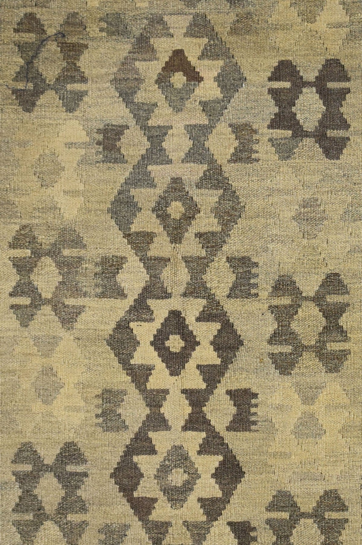 Handmade Afghan Maimana kilim rug featuring a geometric pattern in natural wool tones.