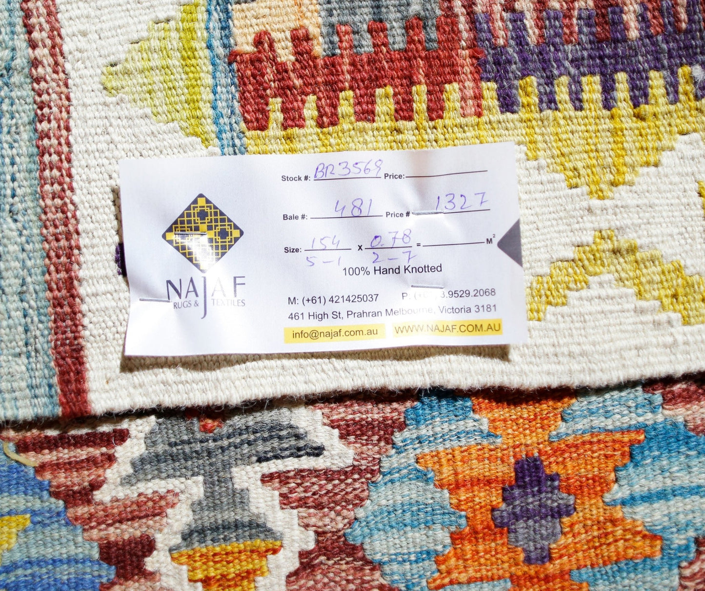 A handwoven Afghan Maimana kilim featuring vibrant geometric patterns in wool.