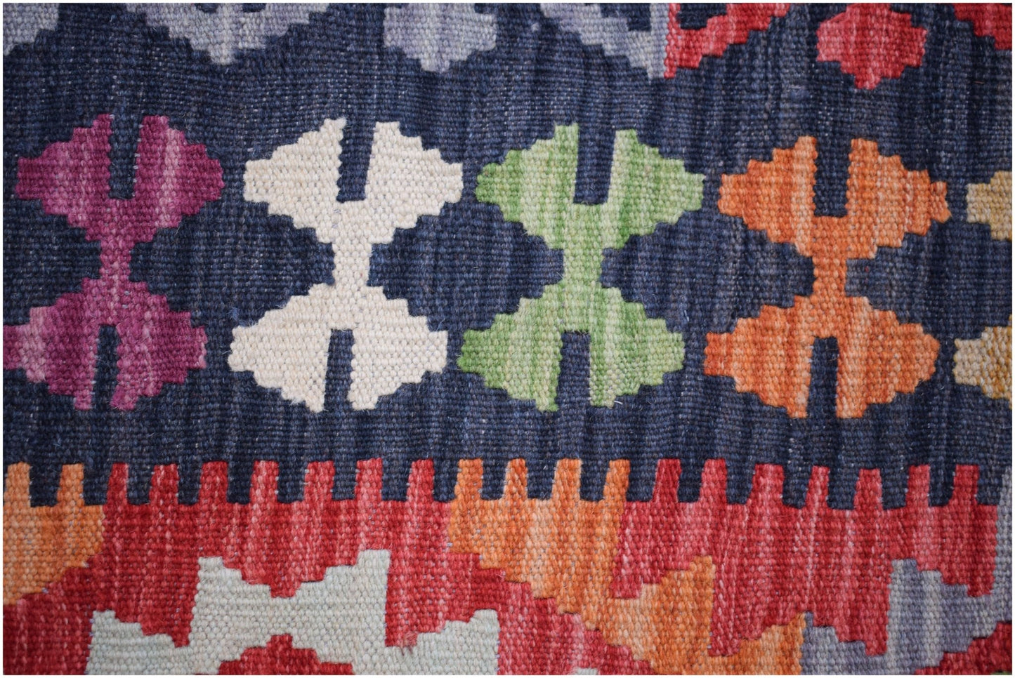 Handwoven Afghan Maimana kilim featuring a geometric pattern in vibrant wool colors.