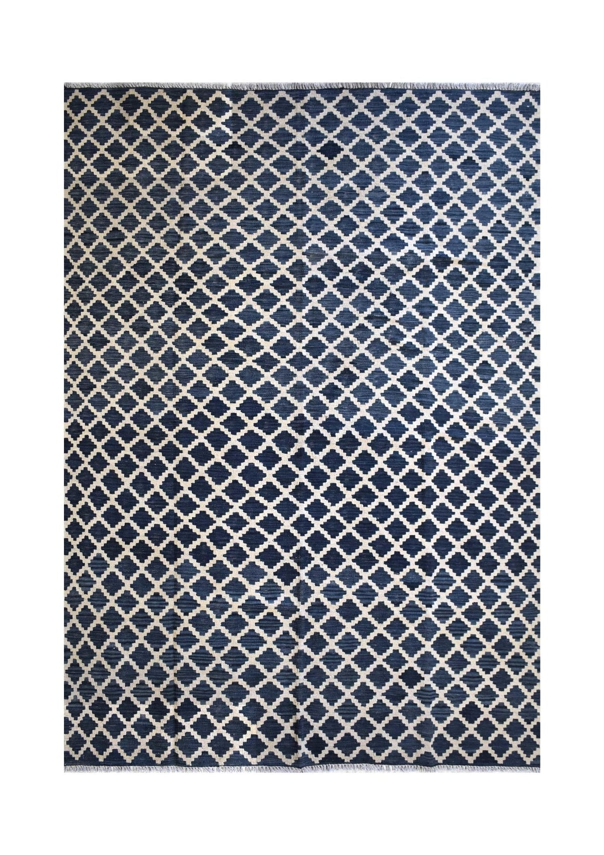 Handmade Afghan Maimana kilim rug featuring a repeating white geometric lattice on a navy blue field.