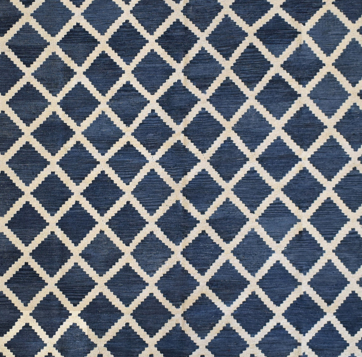 Handmade Afghan Maimana kilim rug featuring a dark blue and cream geometric diamond pattern.