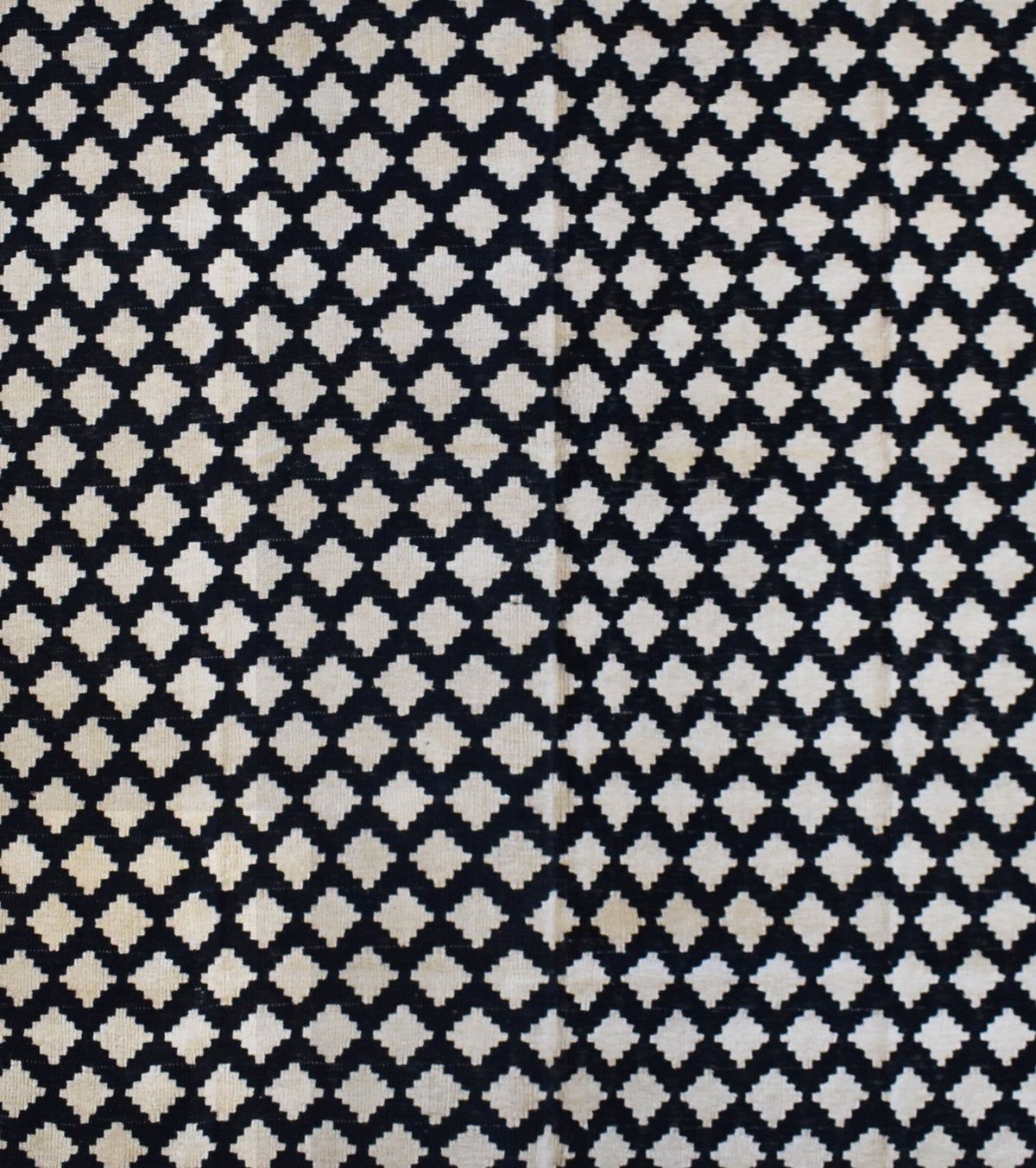 Handmade Afghan Maimana kilim rug featuring a repeating black and cream geometric diamond pattern.