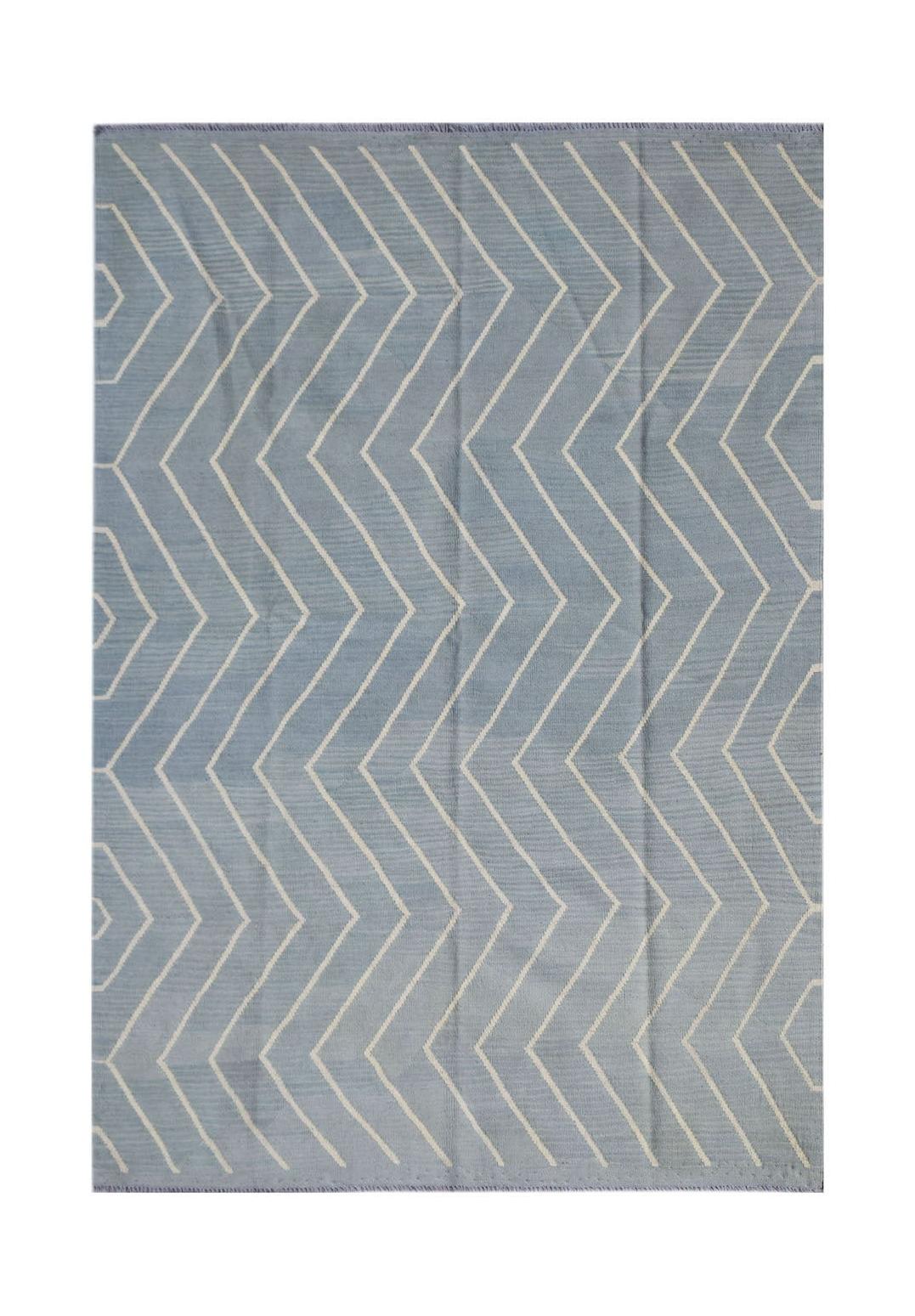 A handmade Afghan Maimana kilim rug featuring a light blue field with a white chevron pattern.