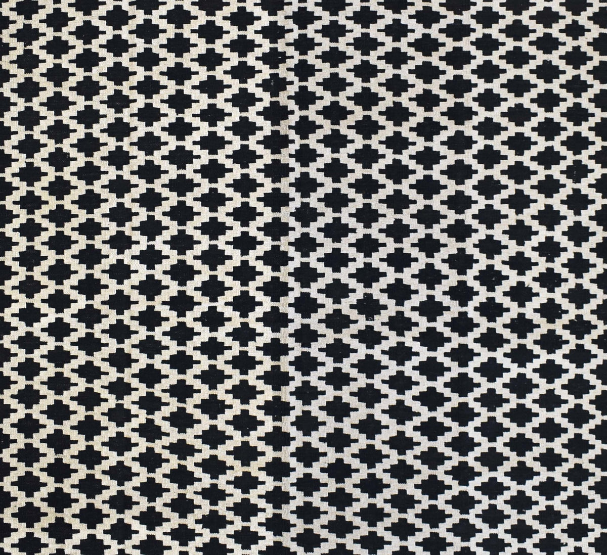 Handmade Afghan Maimana kilim rug featuring a repeating black and white geometric pattern.