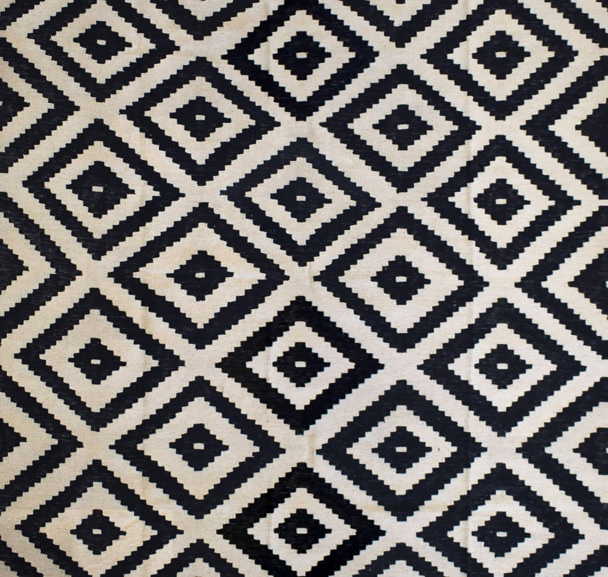 Handmade Afghan Maimana kilim rug featuring a repeating black and cream geometric diamond pattern.