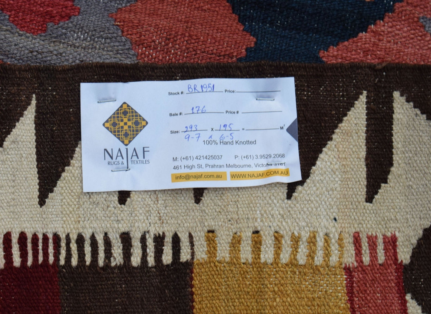 A handwoven Afghan Maimana kilim featuring a geometric pattern in rich red, blue, and brown tones.