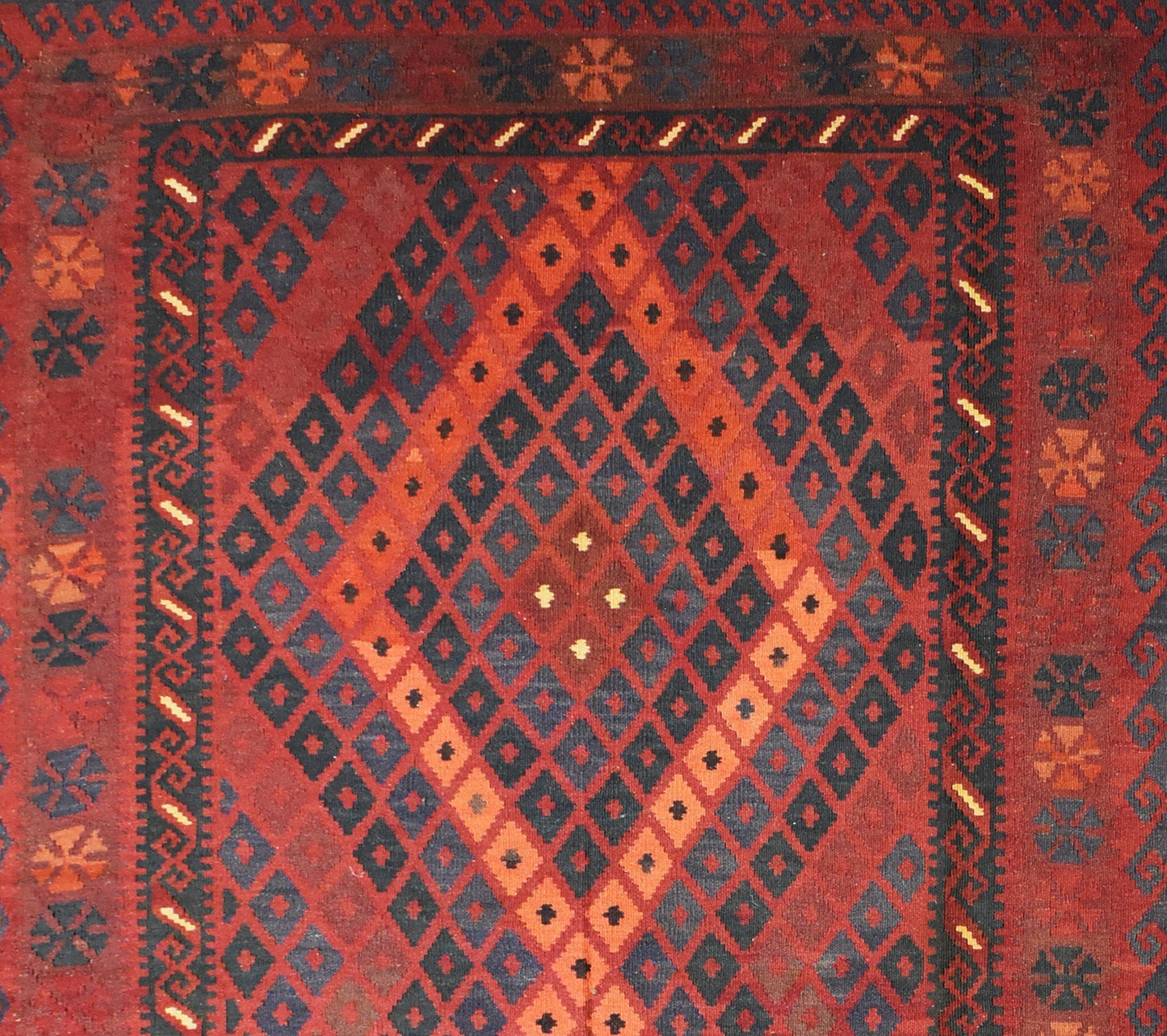 Handmade Afghan Maimana kilim rug featuring a geometric diamond pattern in red and dark blue.