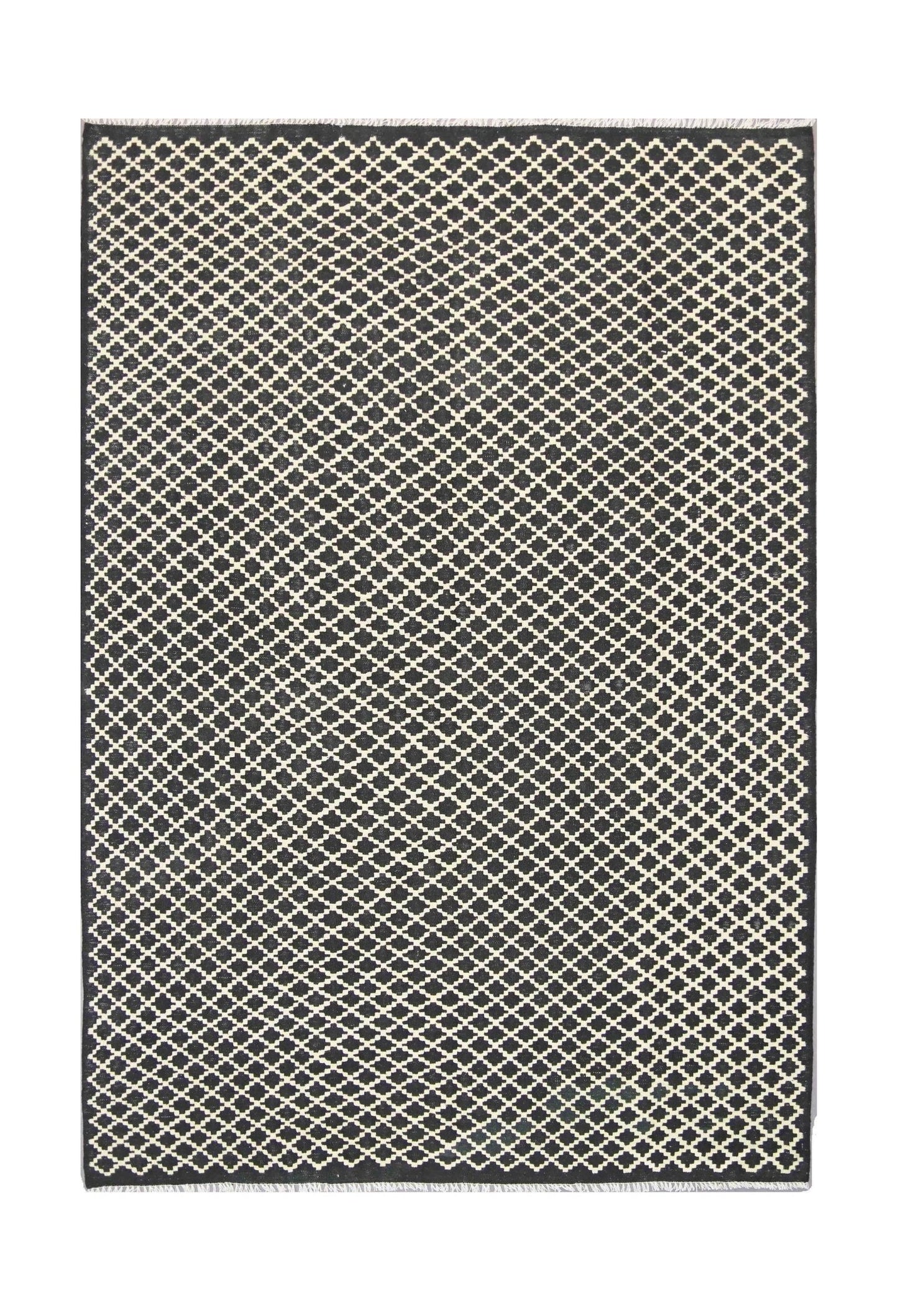 A handmade Afghan Maimana kilim rug featuring a repeating black and cream geometric lattice pattern.