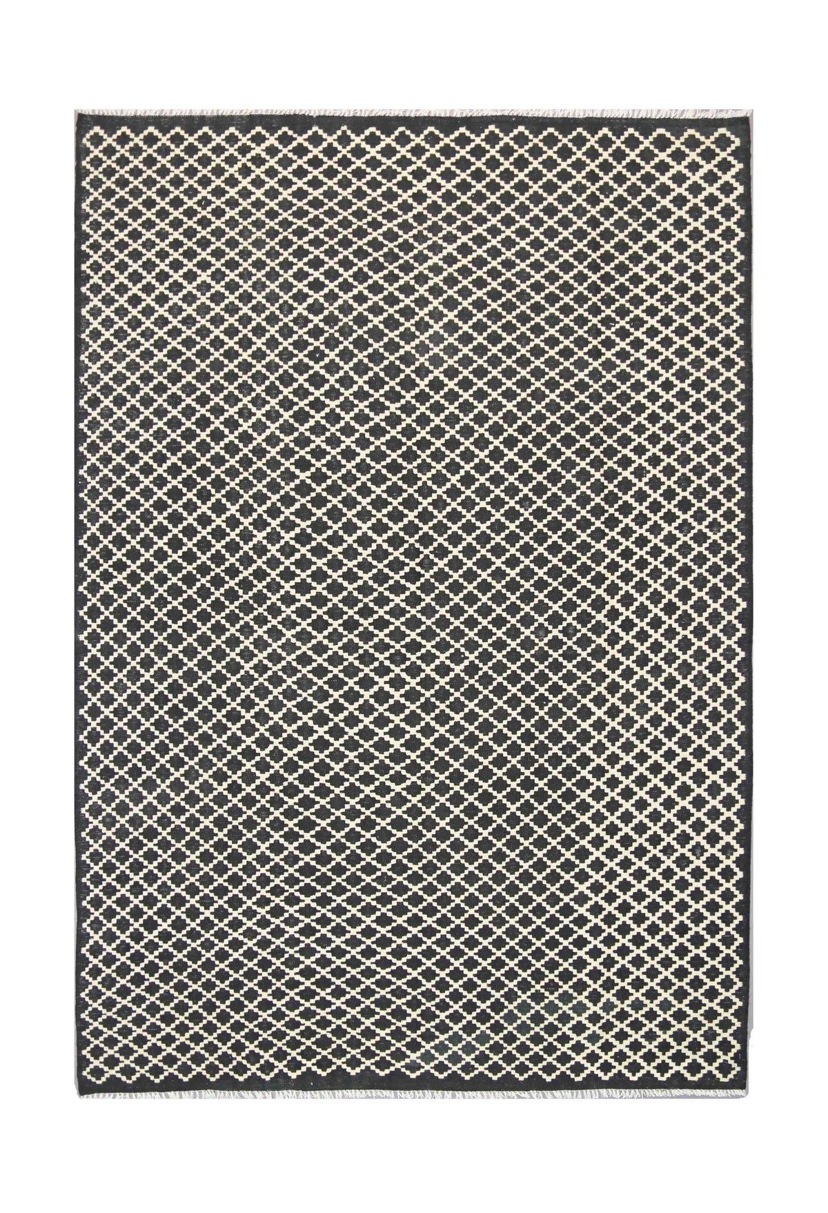 A handmade Afghan Maimana kilim rug featuring a repeating black and cream geometric lattice pattern.