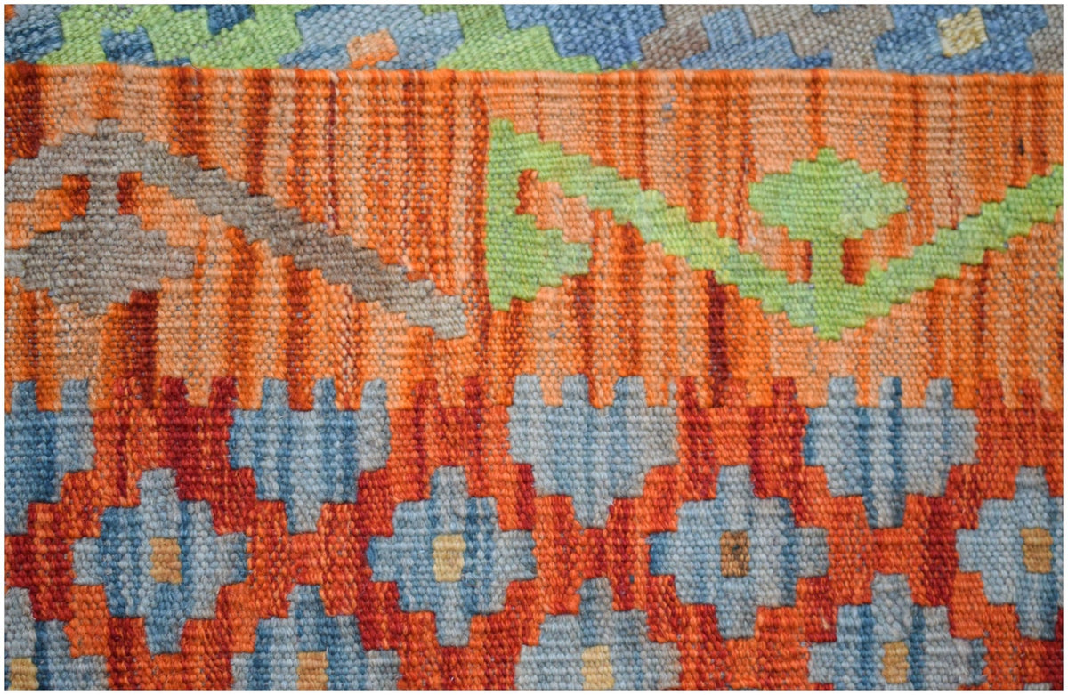 Handwoven Afghan Maimana kilim featuring geometric patterns in orange, blue, and green wool.