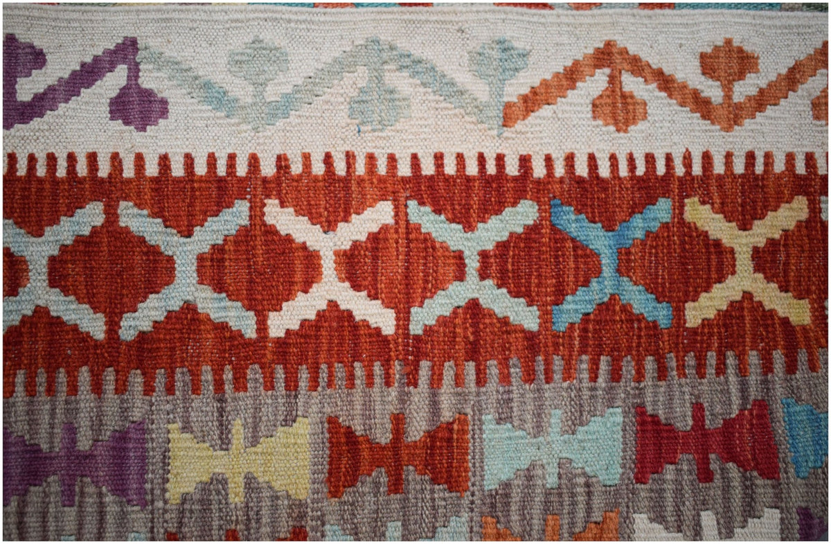 Handwoven Afghan Maimana kilim featuring geometric patterns in vibrant multicolored wool.
