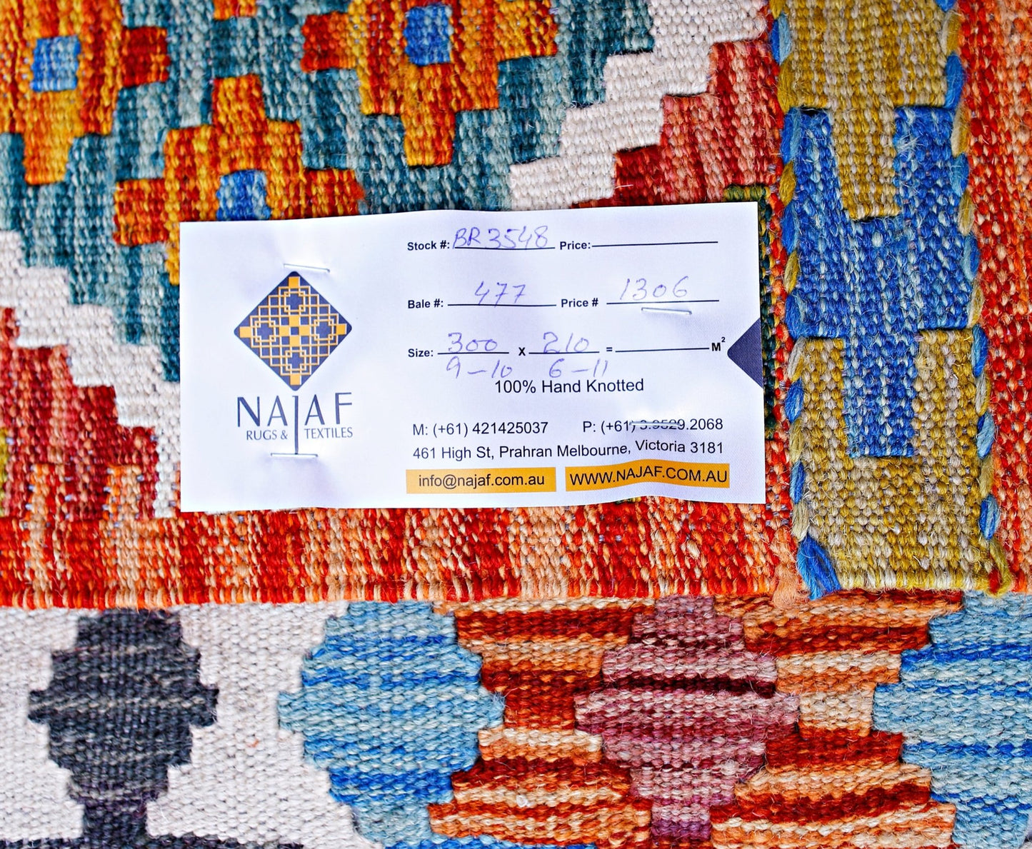 A handwoven Afghan Maimana kilim featuring a vibrant geometric pattern in wool.