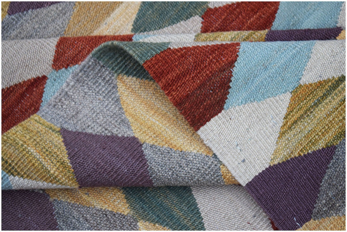 Handwoven Afghan Maimana kilim rug featuring a colorful geometric pattern of triangles.
