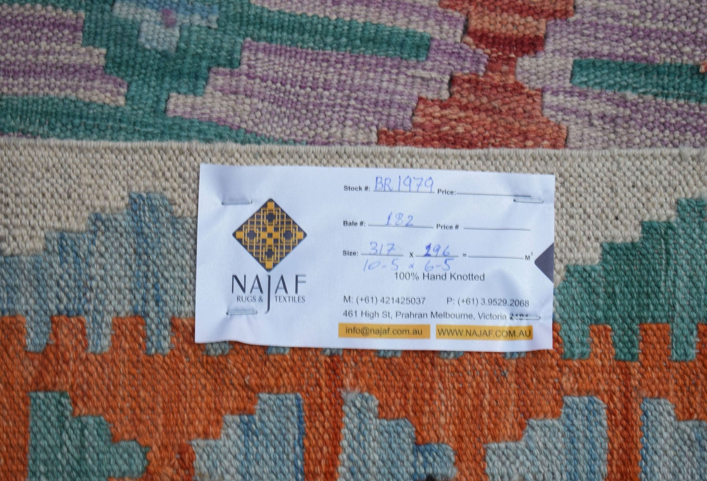 A handwoven Afghan Maimana Kilim rug featuring a colorful geometric pattern.
