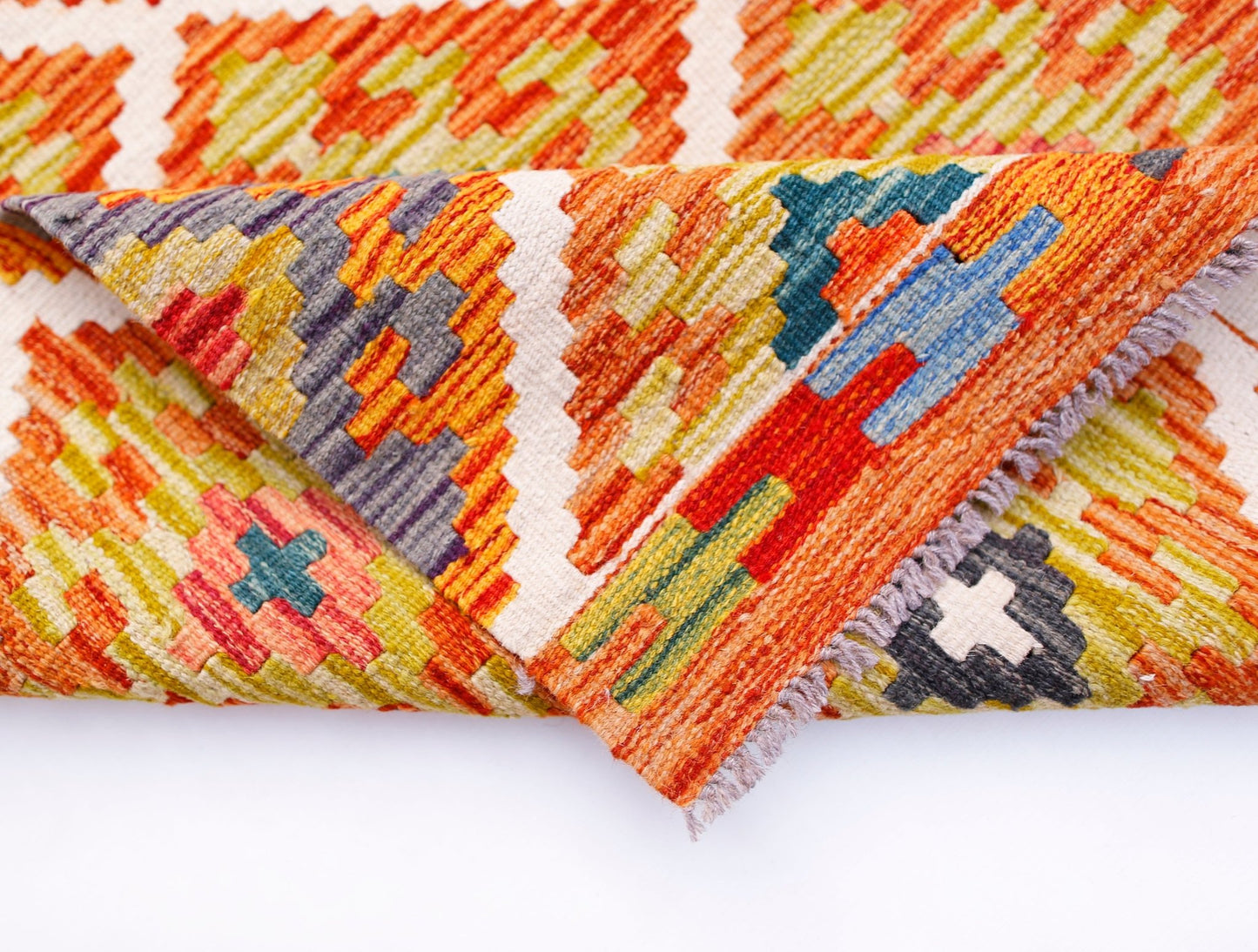 A handmade Afghan Maimana wool kilim runner featuring a vibrant geometric pattern.