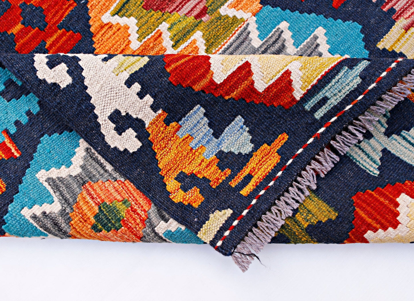 A handmade Afghan Maimana kilim runner featuring a vibrant geometric pattern in wool.