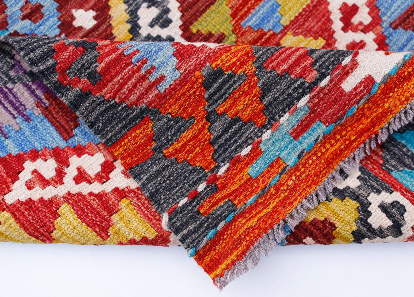 A handwoven Afghan Maimana kilim runner featuring a vibrant geometric pattern in wool.