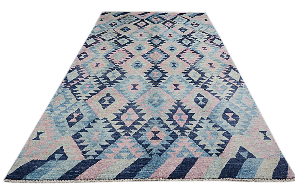 A handmade Afghan wool rug featuring a geometric diamond pattern in shades of blue and pink.