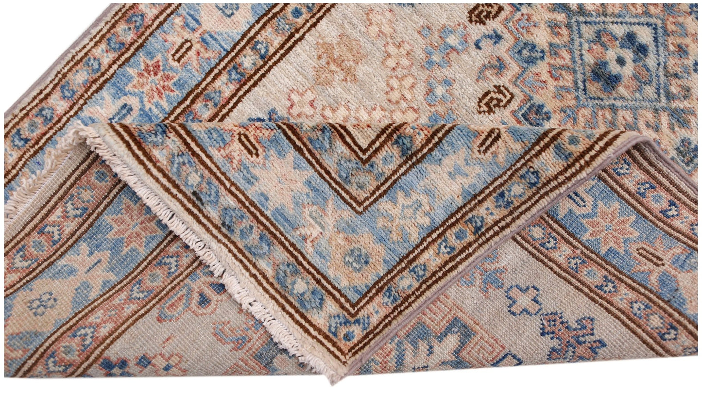 A folded Afghan Super Kazakh runner featuring traditional blue and beige geometric patterns.
