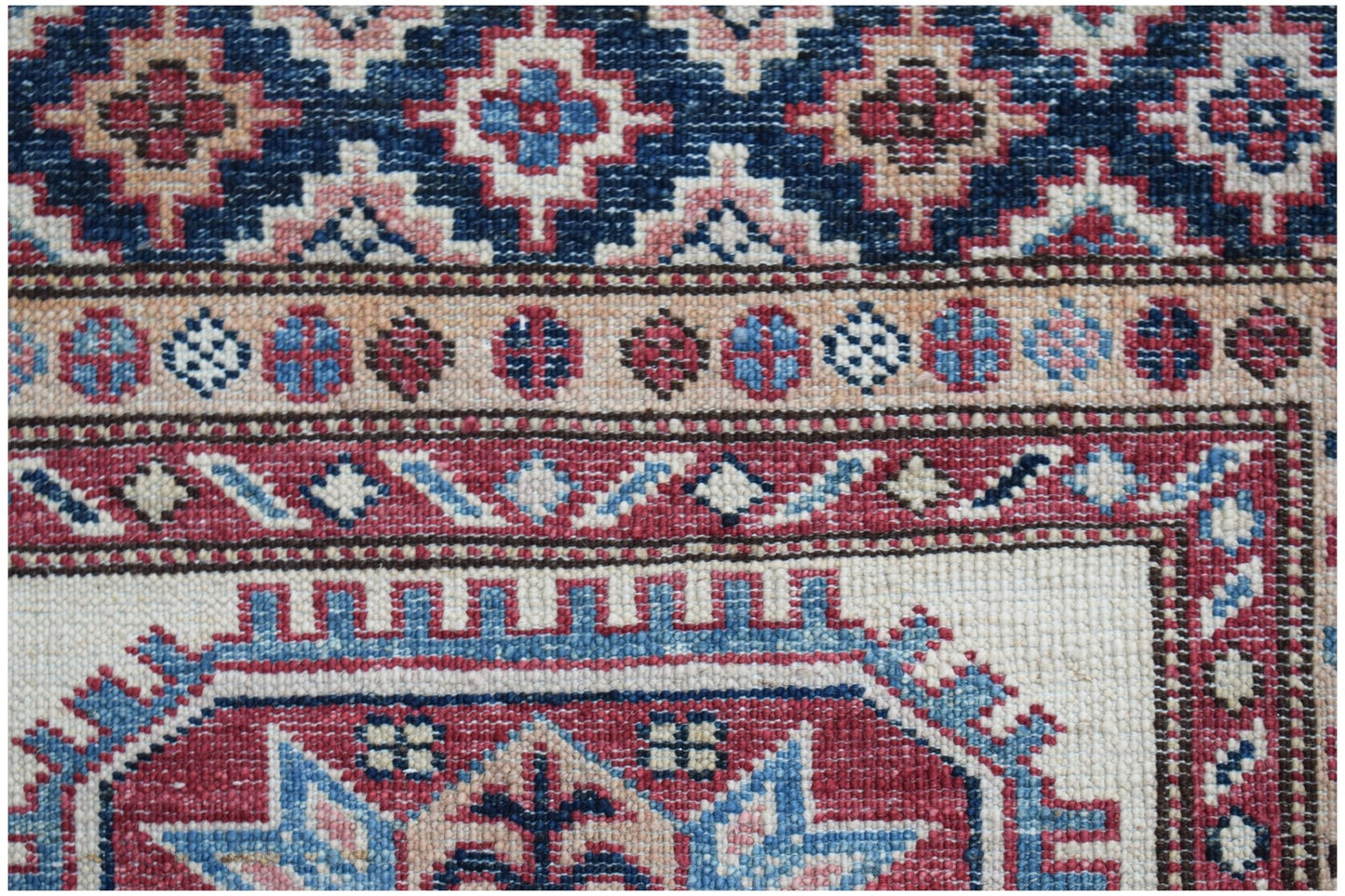 Handmade Afghan Super Kazakh runner featuring traditional geometric motifs in red, blue, and cream.