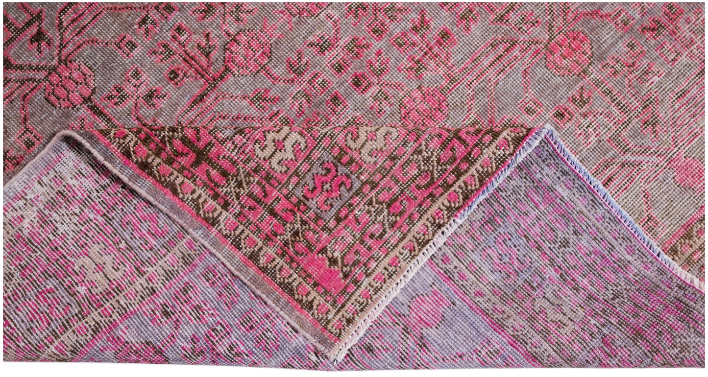 An antique handwoven Khotan rug featuring an intricate pomegranate pattern in vibrant pink tones.