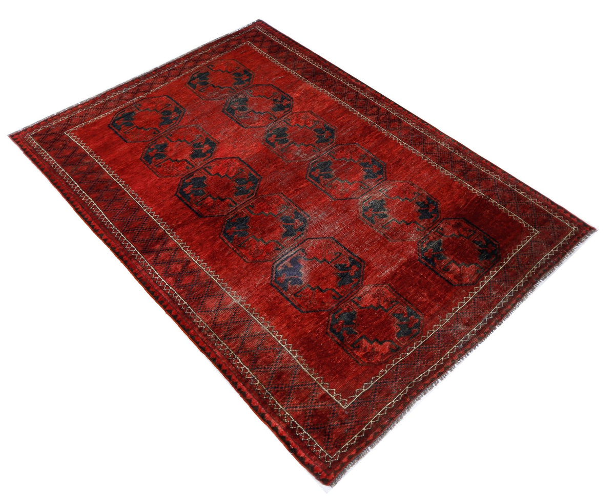 Antique Turkmen Ersari rug with red field, blue elephant's foot gul motifs, and hand-knotted wool pile on white background.