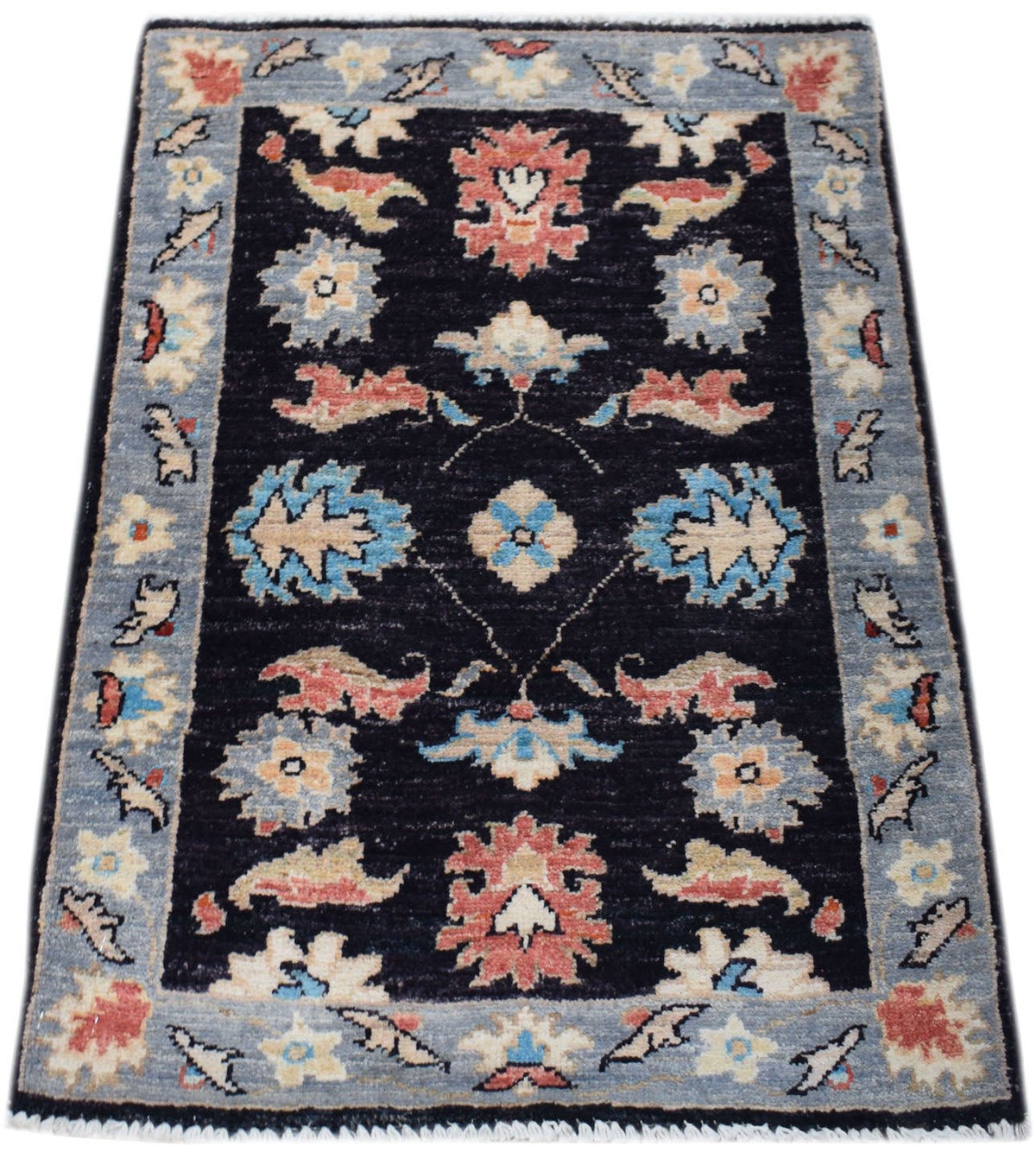 Miniature Afghan Chobi rug with a black field, intricate floral motifs in blue and terracotta, and a light blue border.