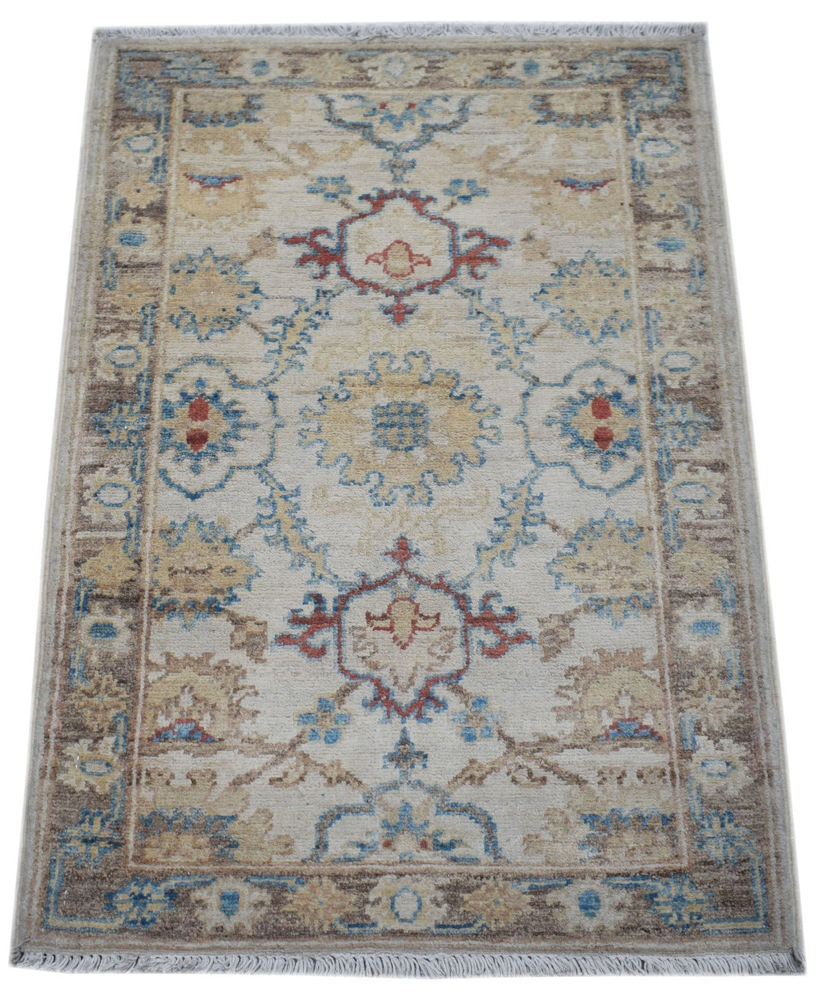 Hand-knotted miniature Afghan Chobi rug with a cream field, intricate blue and rust floral motifs, and a short knotted fringe.