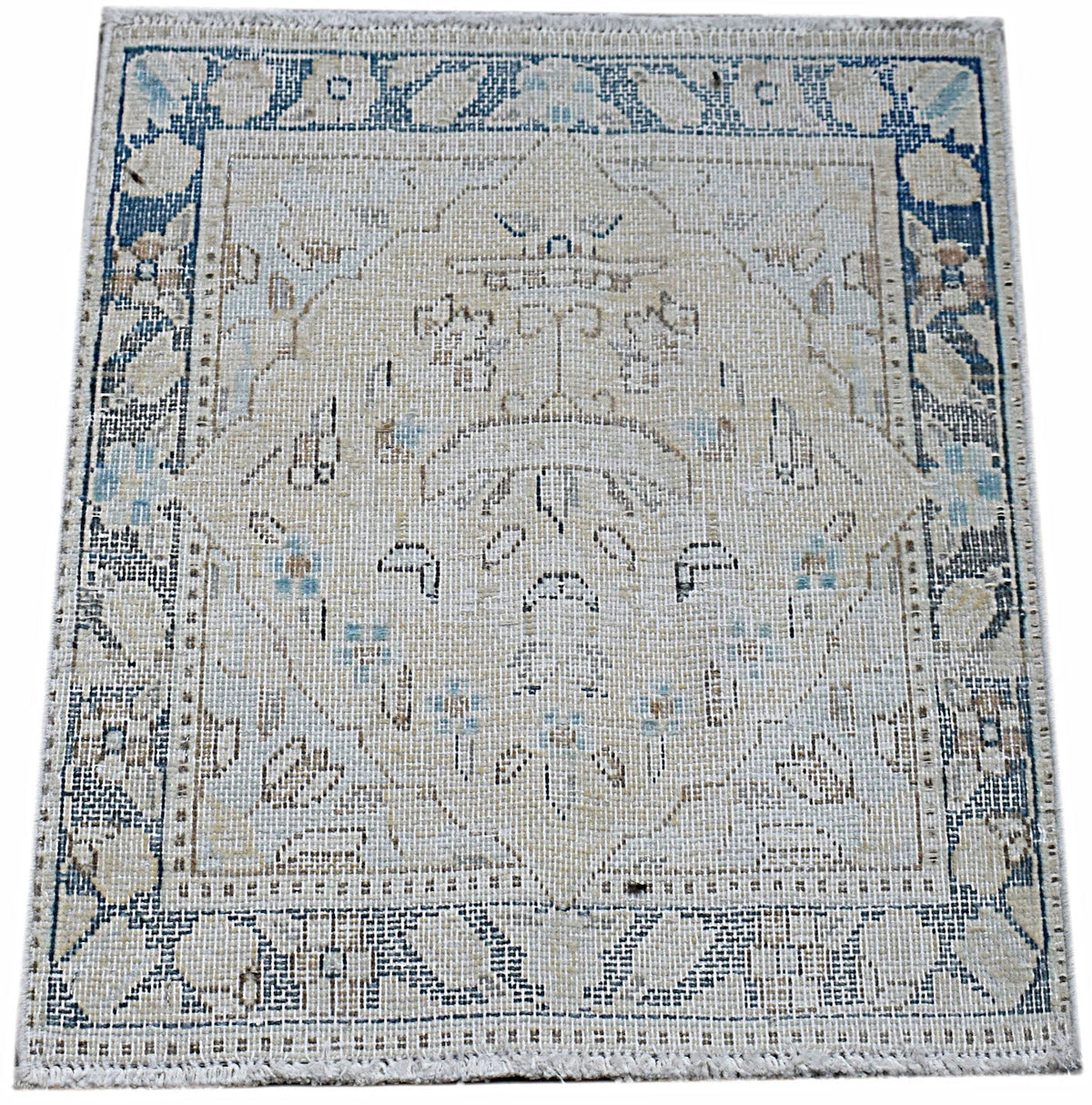 Mini vintage Persian Kerman rug featuring a central floral medallion in soft blue, cream, and brown tones with a detailed border.