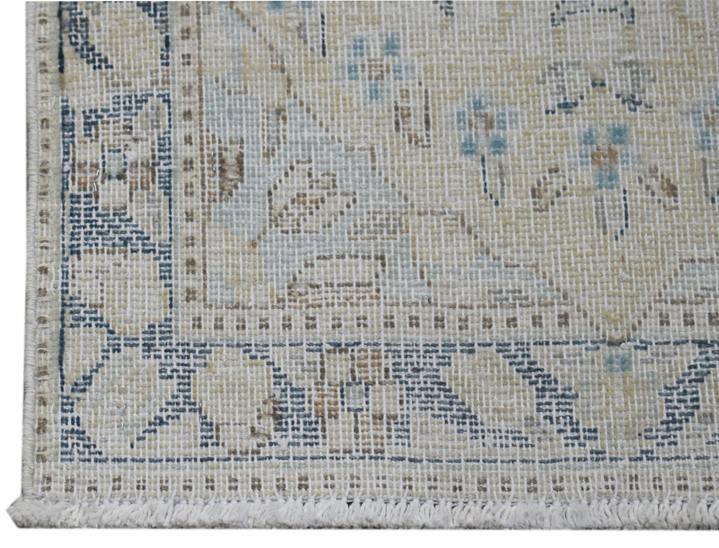 A close-up of a vintage Persian Kerman rug featuring intricate floral patterns in muted tones.