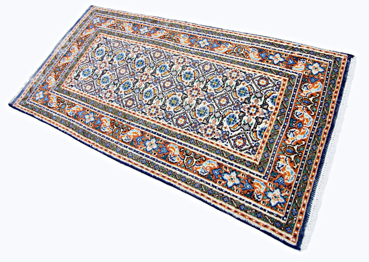 Hand-knotted mini vintage Persian rug with intricate blue, orange, and cream floral patterns and a white fringe.