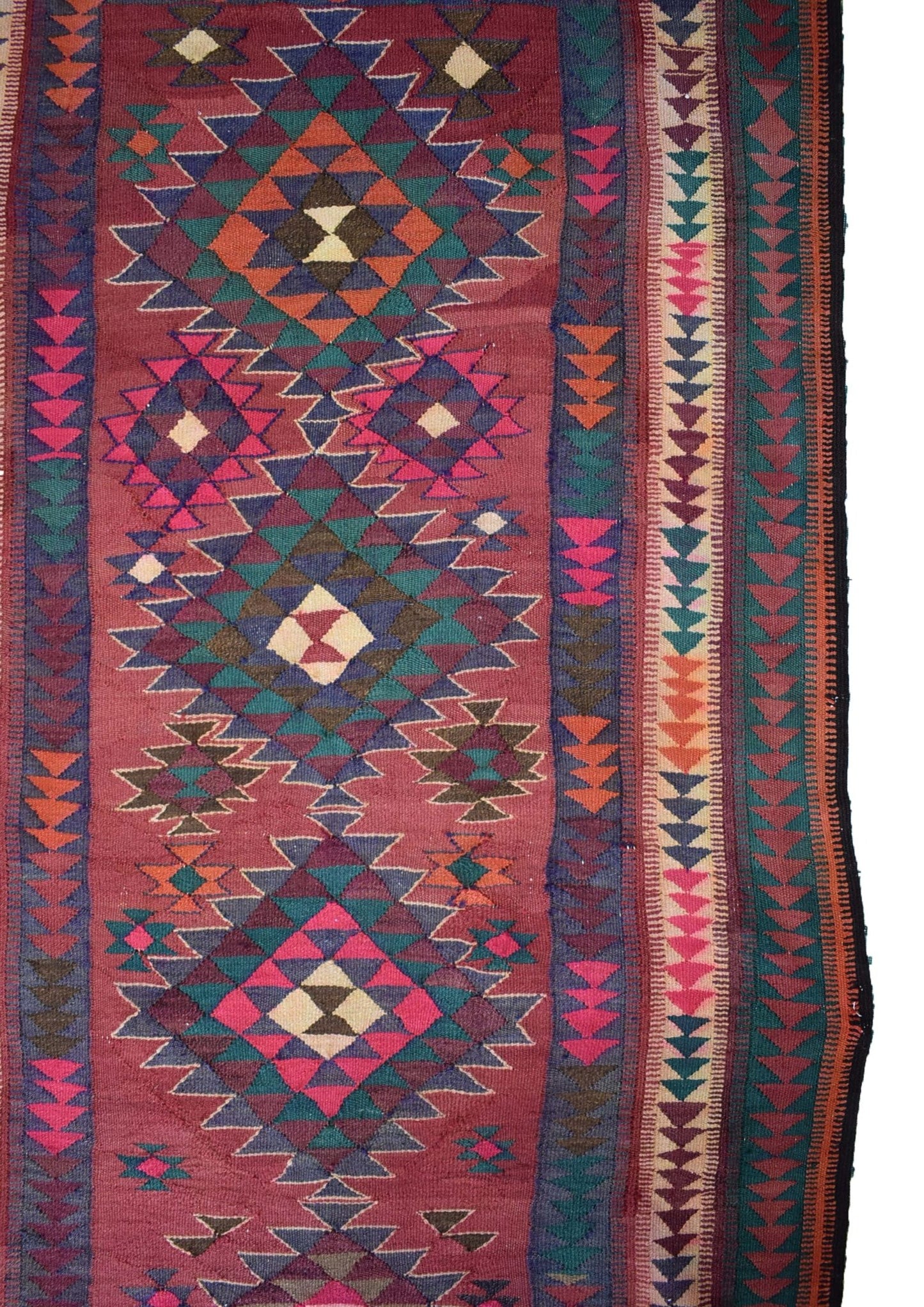 A handmade Persian tribal kilim rug featuring geometric diamond patterns in red, blue, and green.