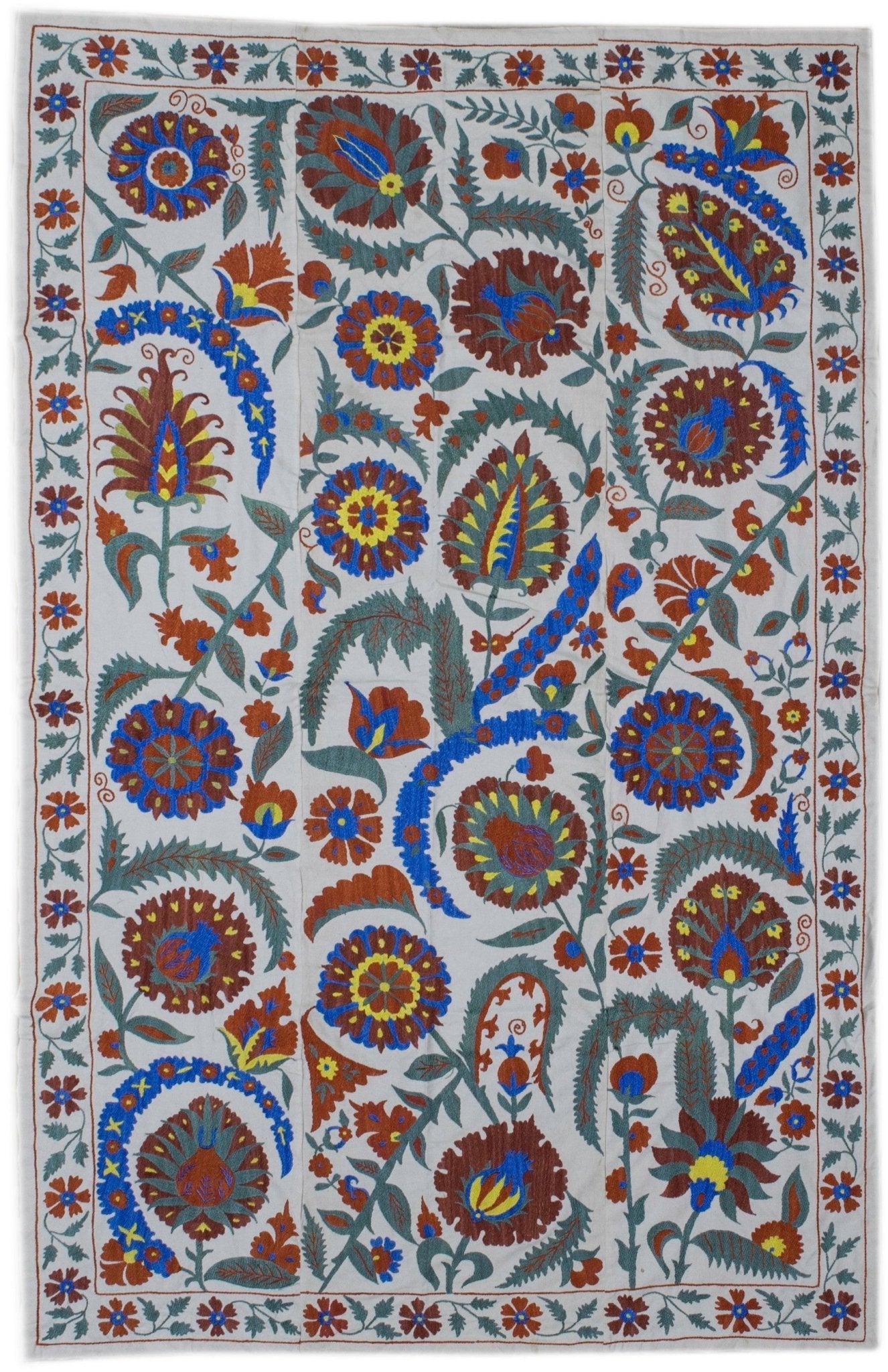 Handmade Uzbek suzani featuring intricate floral silk embroidery on a white cotton base.