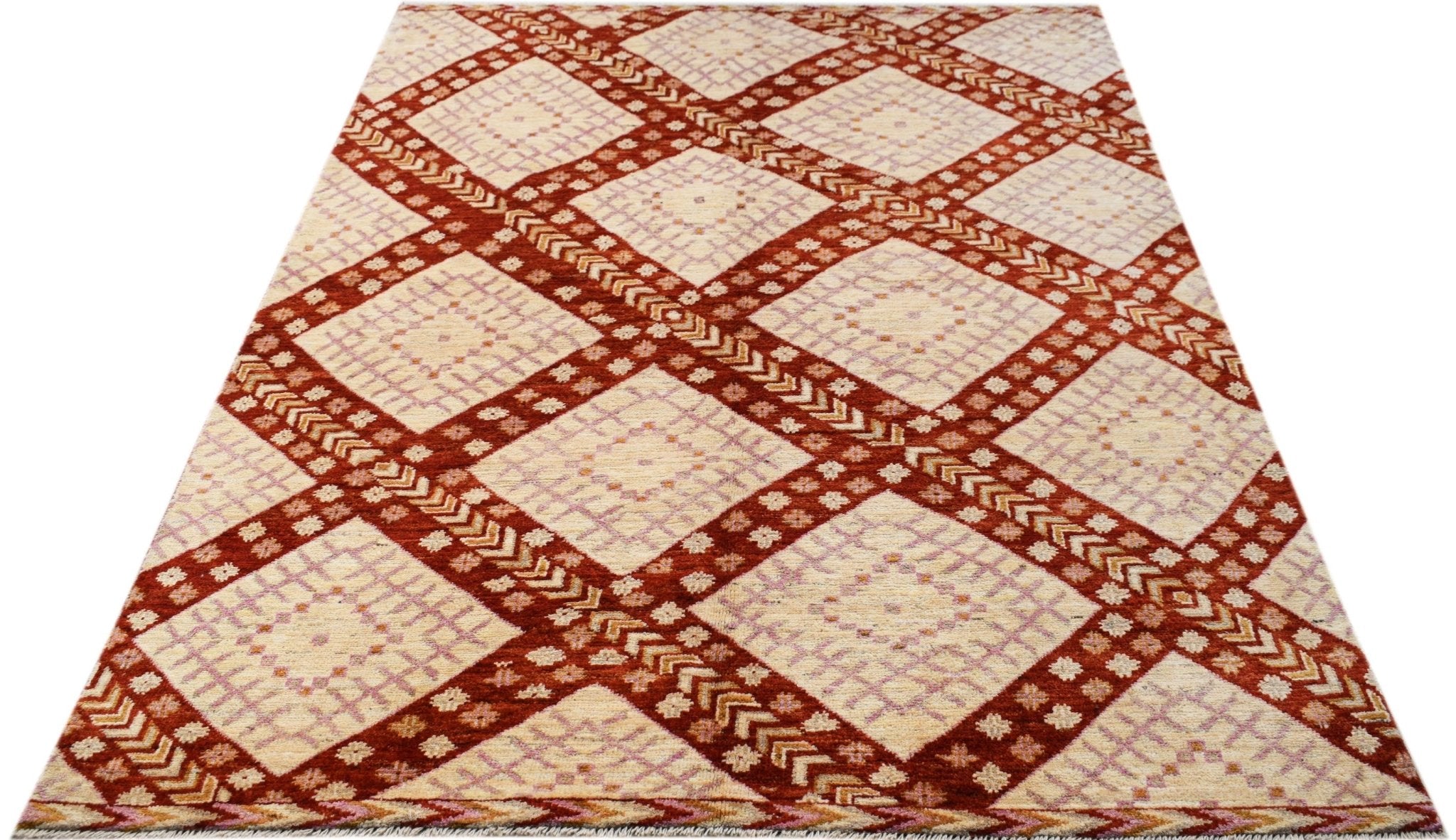 A hand-knotted wool rug featuring a repeating diamond pattern in rust red and cream tones.