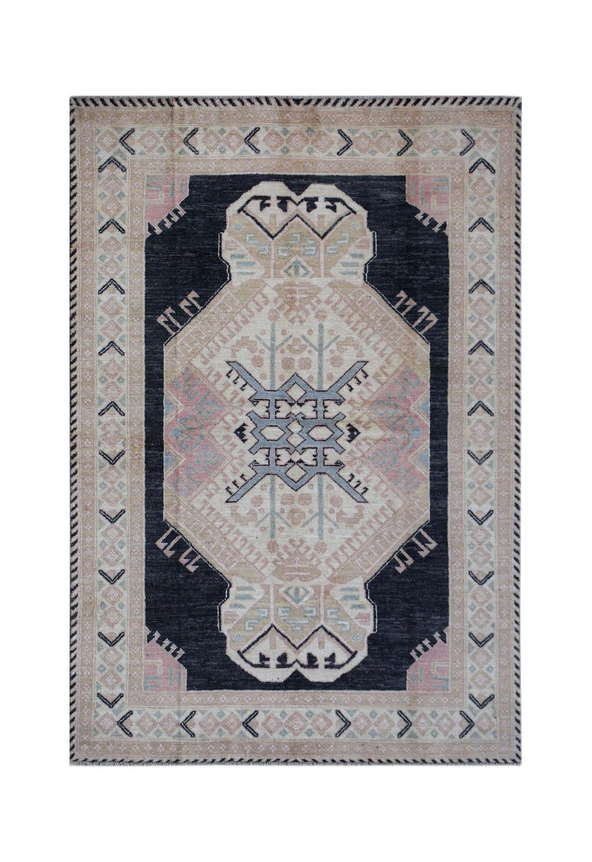 A handmade wool rug featuring a dark central medallion with geometric patterns in pink and blue.