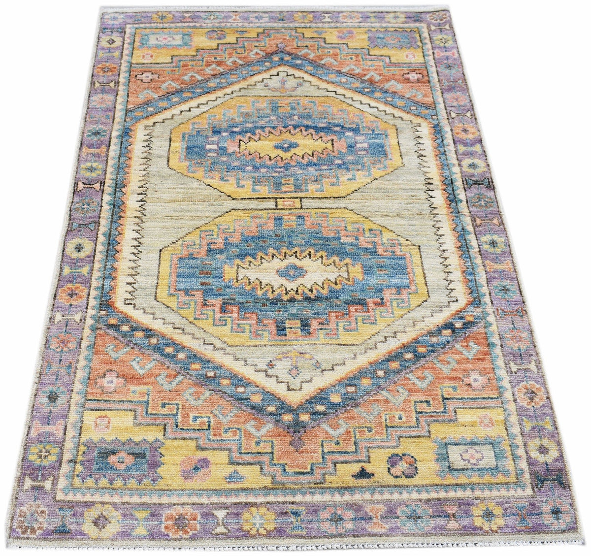 Hand-knotted Afghan Oushak rug with a geometric medallion pattern in soft blue, yellow, and orange wool.