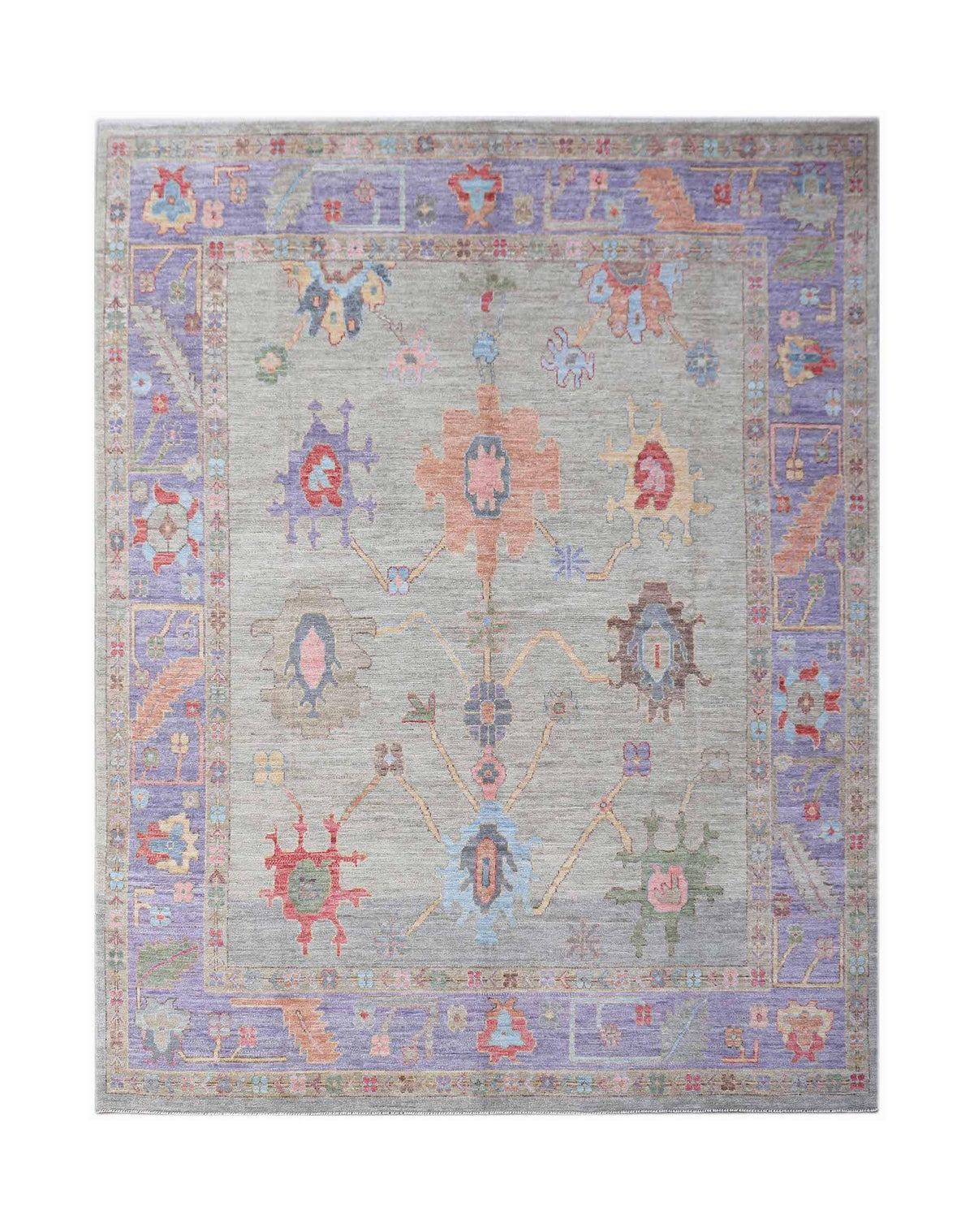 A handwoven transitional Oushak rug featuring a floral pattern in soft colors on a grey field.
