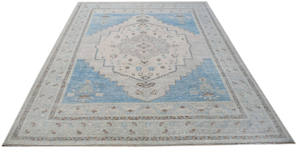Hand-knotted Afghan wool Oushak rug featuring a large-scale medallion in soft blue, cream, and muted brown tones.