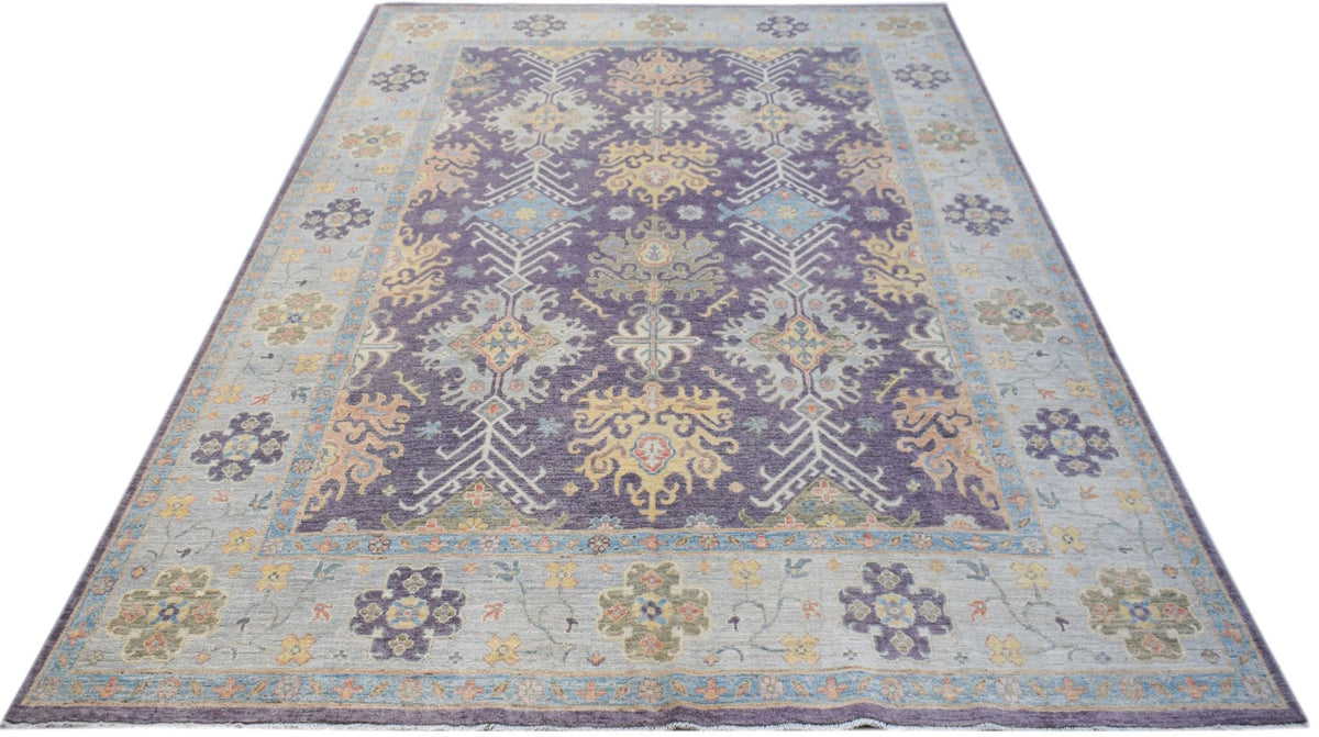 Hand-knotted Afghan Oushak rug in purple and soft muted tones with a traditional large-scale floral pattern.